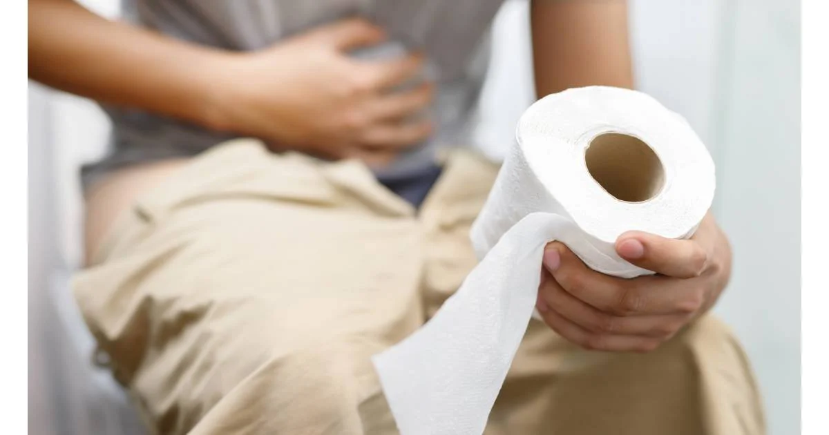 sitting on the toilet suffering with diarrhea from parasites